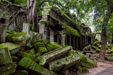 Green moss covered stone and bricks beautiful a temple ruin building architecture in Ta Prohm Tomb Raider jungle forest Angkor Wat historical park in Seim Reap Cambodia on a cloudy overcast day