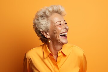 Sticker - Portrait of happy senior woman laughing, isolated on orange background.