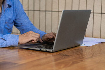 Hands on laptop computer keyboard, searching for information, surfing the internet on a remote work desk. working online business and technology close-up image