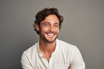 Wall Mural - Portrait of a handsome young man smiling while standing against grey background