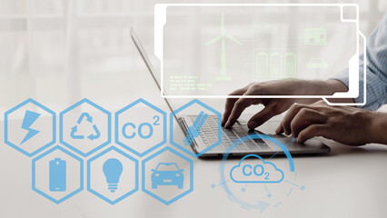 Net zero carbon dioxide reduction concept. CO2 reduction. Hand pressed icon surrounded by renewable energy symbols while using computer.