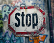 A stop sign with graffiti on it, symbolizing vandalism and disregard for traffic rules.
