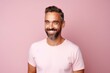 Portrait of a handsome middle-aged man with a beard on a pink background