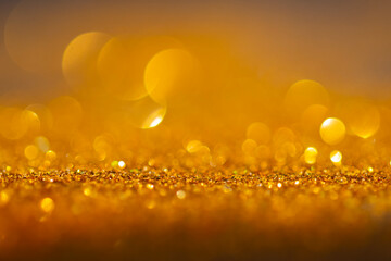 close-up of Golden flakes are scattered on the black surface. shallow depth of field gold particle for graphic resources.