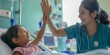 woman nurse or medical staff give a high five to little girl patient
