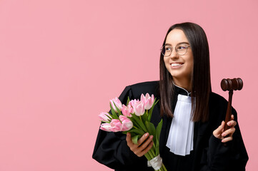 Poster - Young female judge with tulips on pink background. Women's Day celebration