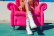 hot pink armchair, person in retro outfit, white gogo boots