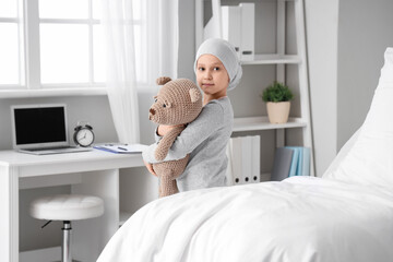 Wall Mural - Little girl after chemotherapy with toy bear in clinic. International Childhood Cancer Day