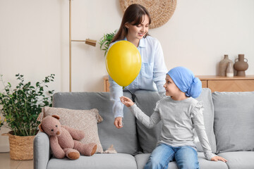 Wall Mural - Little girl after chemotherapy with blue balloon and her mother at home. International Childhood Cancer Day