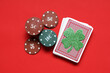 Leinwandbild Motiv Poker chips, deck of cards and lucky clover on red background. St. Patrick's Day celebration