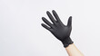 Hand is wear black latex glove on white background.