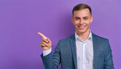 Portrait of a cheerful young adult businessman in a denim shirt and glasses, smiling and pointing towards copy space, isolated on a purple background.