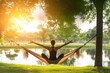 yoga pose in hammock, serene park around