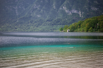 ssummer house on the shore of an alpine mountain lake with clear clean turquoise water