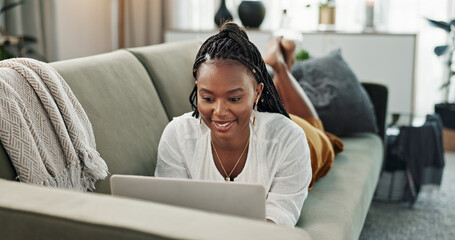 Poster - Black woman on sofa, relax or typing on laptop for remote work, social media or blog post research with smile in home. Happy girl on sofa with computer checking email, website or online chat in house