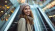 © Oulaphone - Smiling young fashion woman holding colorful shopping bag standing on mall escalator