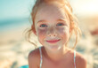 sensitive extremely close-up face portrait of beautiful Red hair little girl with grey eyes clean skin and freckles looking at camera on ocean sandy vacation day. Kids' beauty, fashion and skin care.