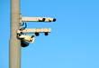 Traffic control street cameras mounted on the pole against clear blue cloudless sky