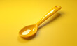 a yellow cooking spoon made of plastic isolated on a complimentary matching background