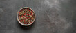 Various peppercorns in a bowl on a dark background. Mix of four peppers. Top view, banner.