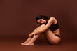 © deagreez - Full length photo no filter of lovely young lady sit floor hug legs relax wear trendy lingerie isolated on brown color background