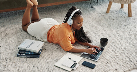 Fototapete - Laptop, headphones and young woman on the floor in living room of modern apartment. Tech, smile and young African female university student study and listen to music on computer in lounge at home.