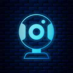Poster - Glowing neon Web camera icon isolated on brick wall background. Chat camera. Webcam icon. Vector