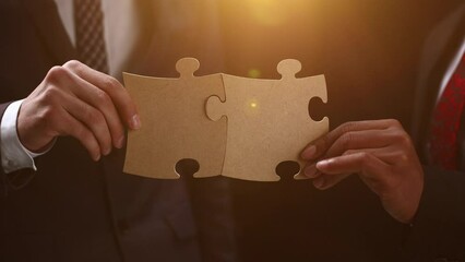 Wall Mural - See the big picture. Close-up of an unidentified business man holding two puzzle pieces together.