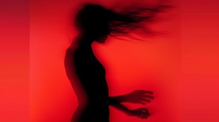 Wall Mural - Female blurred silhouette on a red background. Elegant outline of a woman in motion out of focus