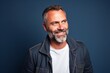 Portrait of a handsome middle-aged man smiling over blue background.
