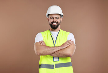 Wall Mural - Engineer with hard hat and badge on brown background