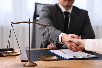 Wall Mural - Notary shaking hands with client at wooden table in office, closeup