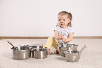 Wall Mural - Cute little girl with cookware at home