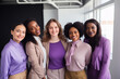 © ToveStock - Smiling women in business outfits posing together in a modern office setting
