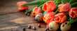 Easter eggs with red tulips lie on a wooden background.