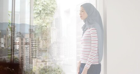 Wall Mural - Animation of cityscape over biracial woman in hijab thinking