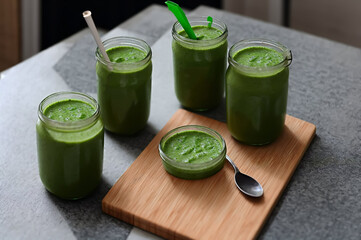Wall Mural - Healthy green smoothie in glass jars with straws on table
