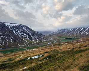 Wall Mural - View during auto trip in Iceland. Spectacular Icelandic landscape with  scenic nature: mountains, bottom lands, river, clouds, waterfalls.