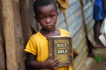Wall Mural - Poor young african kid with Bible.