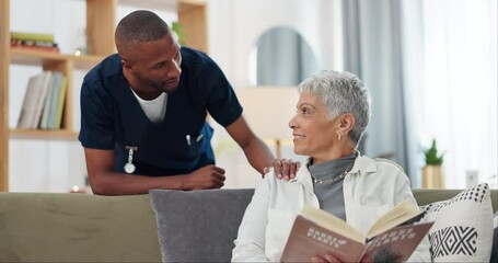 Wall Mural - Senior, woman and nurse on sofa with support, conversation and caregiver in living room of retirement home. Elderly, person and black man with kindness, happiness and discussion while reading a book