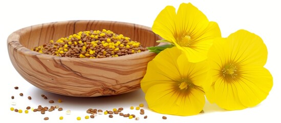 Wall Mural - Yellow flower and mustard seeds in a wooden bowl, isolated on a white background.