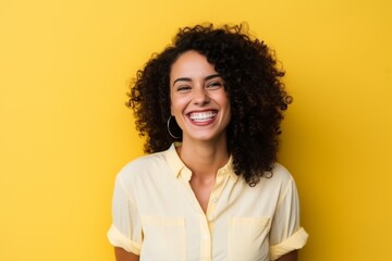 Wall Mural - Portrait of a beautiful young african american woman laughing over yellow background