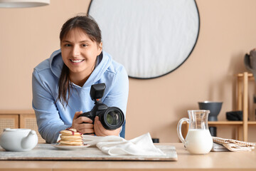 Wall Mural - Female food photographer with camera shooting tasty pancakes in studio