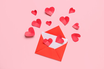 Composition with envelope, card and red paper hearts on pink background. Valentines Day celebration