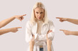 People pointing at mature woman on light background. Accusation concept