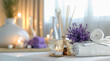 An image for advertising aromatherapy and massage: a table with white towels, incense sticks, candles, aromatic oil and a bouquet of lavender.