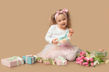 Sticker - Cute little girl with bouquet of beautiful tulips and gift boxes on brown background. International Women's Day