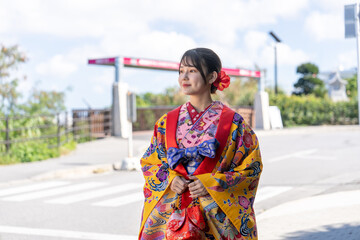 沖縄県豊見城市瀬長のウミカジテラスの海の見える場所で琉装を着た２０代の若い日本人女性 A young Japanese woman in her 20s in Ryukyu dress at a place with a view of the sea on Umikaji Terrace in Senaga, Tomigusuku City, Okinawa Prefecture