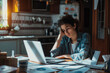 © Alina Zavhorodnii - Sad girl, guy sitting near a laptop with papers scattered on the table, preparing for an exam working with papers in a bad mood