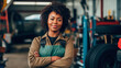 © carolvis - A black female auto mechanic, portrait looking at the camera with an auto mechanic shop in the background and empowered.